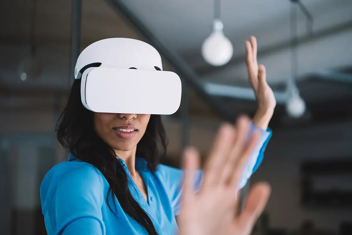 Woman wearing a virtual reality headset and interacting with a digital environment using hand gestures.